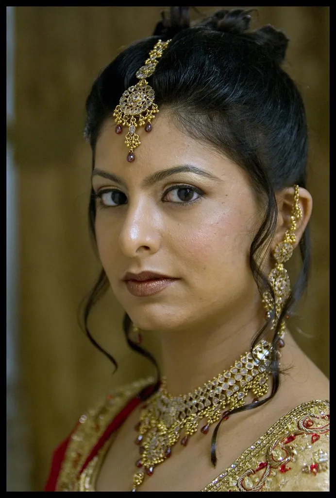 Bridal makeup portrait with gold jewelry and elegant updo hairstyle
